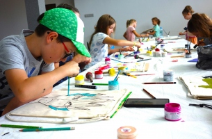 Dzieci podczas malowania swoich plecaków